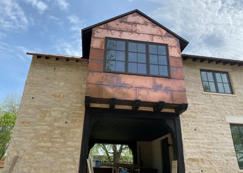 Copper metal panel facade on a stone building for Roof Repair in Salina