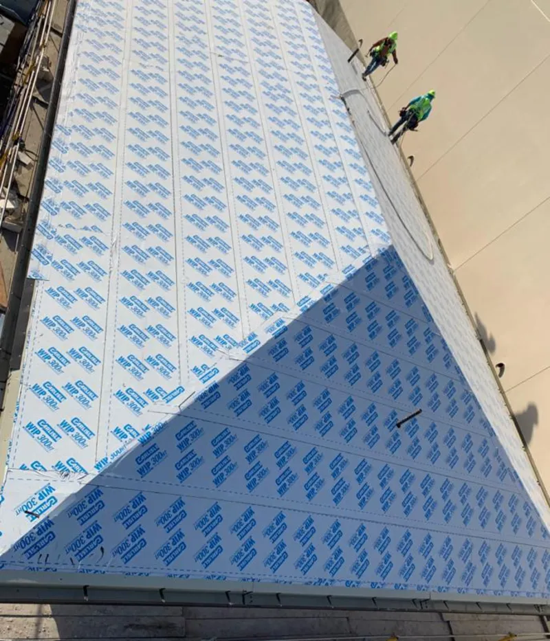 Professional roofers installing underlayment on a metal roof in Salina